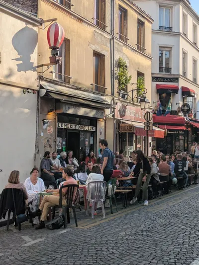 Vue d'ensemble de la terrasse ensoleillée, rue pavée Paris